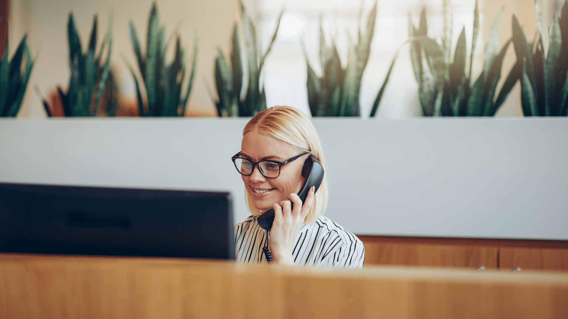 femme au téléphone derrière un bureau